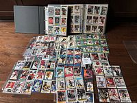 Binder and loose hockey cards spread on floor showing a large collection of cards from multiple years, teams, and players including stars and rookies.