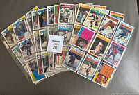 Spread of various OPC hockey cards from 1980s in plastic binder sleeves, showcasing many different players and card designs.