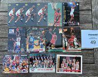 Lot of 13 Michael Jordan basketball cards from 1992-93 and 1993-94 seasons arranged on wooden table with MaxSold bidding card visible.