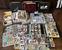 Overview of three binders, two plastic bins, loose card boxes and cards spread out on floor.