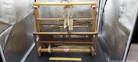 Front view of antique wooden weaving loom showing full frame, warp beam, heddles, and weaving mechanism.