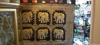 Front view of highly detailed elephant tapestry with gold elephants on black background, showing six elephants arranged in two rows of three with decorative gold borders.
