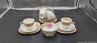 Full set of Royal Albert tea set including bowls, teacups, saucers, and side plates arranged on black background