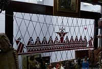 Front-left angled view of full stained glass panel showing red and clear leaded design