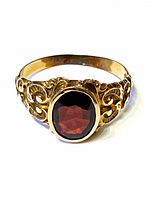 Top view showing deep red faceted oval garnet and scroll filigree shoulders