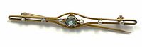 Top-down view of brooch showing gold bar, central blue gemstone and six pearls