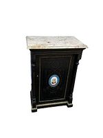 Front view of the cabinet with door closed showing ebonized finish, gilt decoration, and marble top
