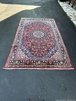 Full overhead view of rug on asphalt showing entire medallion and border design.