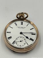 Front view of watch dial showing Roman numerals, blued hands and retailer marking