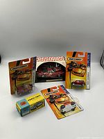 General overview photo of all boxed miniature cars including Matchbox, Corgi, and Eldon cars on plain background.