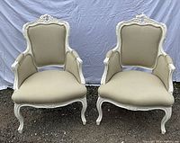 Front view of both painted Louis XV style armchairs showing upholstery and frame design