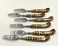 Six forks with detailed Imari pattern handles arranged on white background, showing color and pattern details