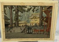 Signed woodblock print by Toshi Yoshida titled "Nikko" showing architectural scene with trees. Print has signature and title in English on front.