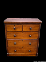 Front view of Victorian mahogany chest of drawers, showing five drawers arranged two small above three larger with original wooden knobs and keyholes.