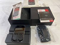 BlackBerry Bold cell phone in original box with user manuals and charging adapter sealed in plastic.