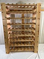 Front view of the full wooden wine rack showing all horizontal slatted shelves and vertical supports.