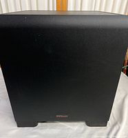 Front view of the Klipsch subwoofer showing the smooth black vinyl finish and small Klipsch logo near the bottom.