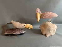 Pair of natural stone bird sculptures; Toucan on amethyst base (left) and Pelican on clear quartz base (right).