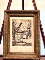 Framed antique etching displayed on stand, showing full piece and frame details.