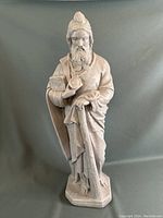 Full view of the stone statue showing St. Jude holding a book and staff, standing on a hexagonal base.