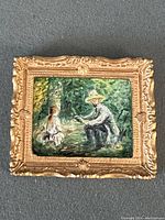 Front view of the miniature oil on board painting in a gold ornate frame showing a man and a young girl in a garden scene.