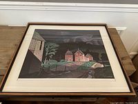 Framed art print of a rural landscape with buildings, signed A.J. Casson.