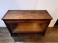 Front view of oak cabinet showing sliding glass door and knob hardware