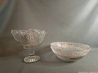 Clear crystal pedestal bowl showing ornate floral pattern and scalloped rim