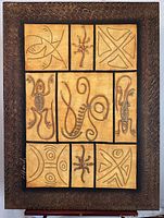 Full view of the mixed media artwork showing nine panels with abstract shapes, lizard and spider motifs, featuring a dark brown textured border.