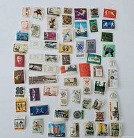 Photo showing an assortment of approximately 65 Polish postage stamps with varying denominations and designs including flowers, historical figures, sports scenes, and abstract art on a white background.