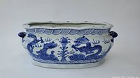 Front and side view of oval planter showing Chinese blue dragon designs and handles