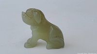 Front side view of the small jade dog carving showing body and face details.