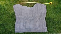 Large irregular piece of grey suede nubuck leather laid flat on grass with measuring tape showing width.