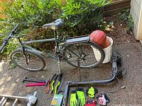 Full view of Montana Assent bike and adjacent accessories including bike stand, gloves and bucket with balls.