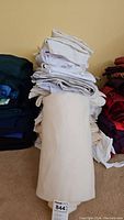 Stack of assorted fabric pieces in various colors and materials piled vertically
