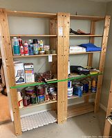Two natural finish wood utility shelving units shown side by side with various household and workshop items stored on shelves.