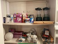 Shelf with various boxed lightbulbs, loose bulbs, batteries, and a battery charger