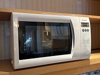 Front view of white Panasonic microwave oven showing door and handle.