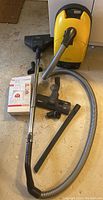 Full set of vacuum cleaner with attachments and AirClean filters on floor
