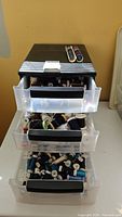 Full front view of resin container showing three open drawers filled with thread spools and two spool racks on top