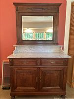 Front view of oak washstand with marble top and framed mirror