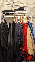 Rack of assorted women’s clothing on hangers with folded items above