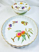 Set of one pie plate and one lidded serving bowl, both decorated with fruit motifs and gold trim
