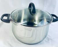 Side and top view of Remy Olivier stainless steel soup pot with black handles and glass lid.