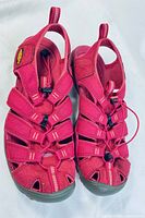 Top view of pair of pink Keen sandals showing multiple straps, adjustable elastic cord, and closed toe design.