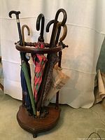 Umbrella stand in use loaded with assorted vintage umbrellas