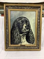 Frontal photo of the oil painting featuring a black and white dog portrait in a gold rustic frame.