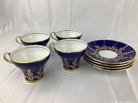 Four cobalt blue Aynsley teacups and matching saucers arranged together showing design and condition.