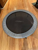 Top view showing round black jumping surface and padded gray ring with brand logo.