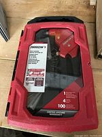 Closed red and black Arrow branded plastic carrying case for riveter kit showing product details and warranty information.